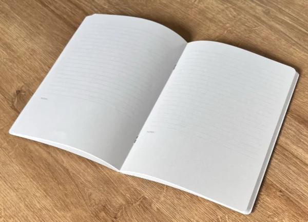 L'image montre l'intérieur d'un carnet conçu et fabriqué en France, par Loup Blanc. Chaque page présente un lignage sur les 2/3 de sa hauteur. Le bas de page est vierge pour accueillir des notes ou des croquis.